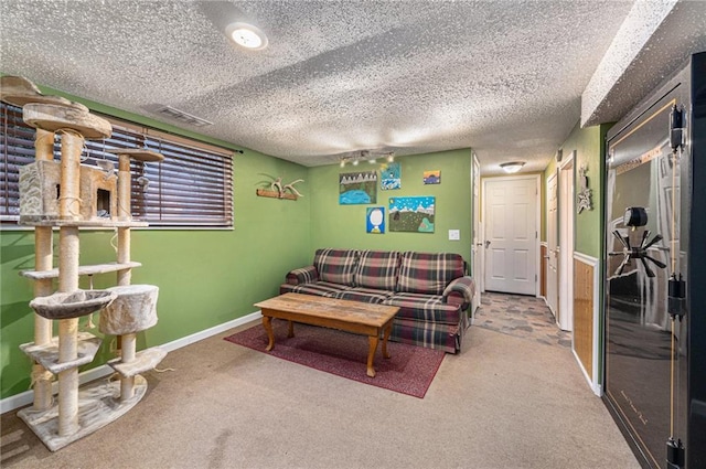 carpeted living room featuring baseboards, visible vents, and a textured ceiling