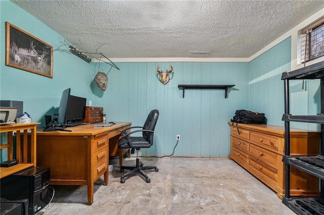 home office with a textured ceiling, visible vents, and concrete flooring