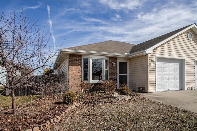 ranch-style home featuring a garage, brick siding, driveway, and roof with shingles