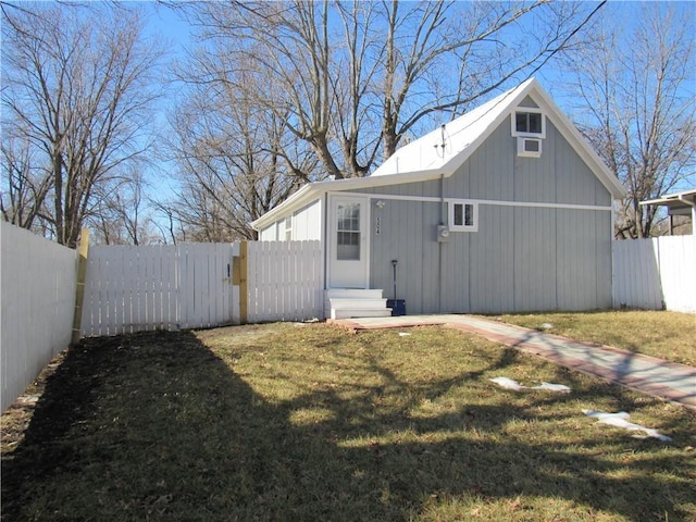 back of property featuring fence and a lawn