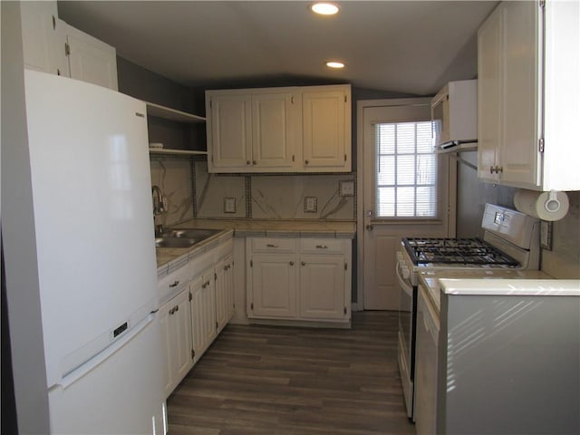 kitchen featuring range with gas cooktop, freestanding refrigerator, light countertops, white cabinetry, and a sink