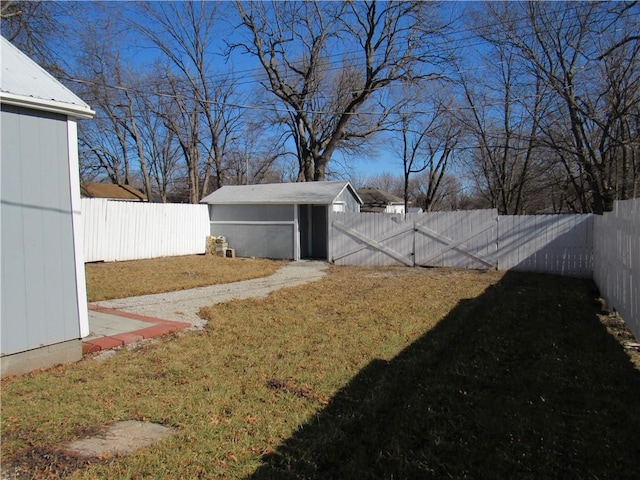 view of yard featuring a storage shed, a fenced backyard, and an outdoor structure