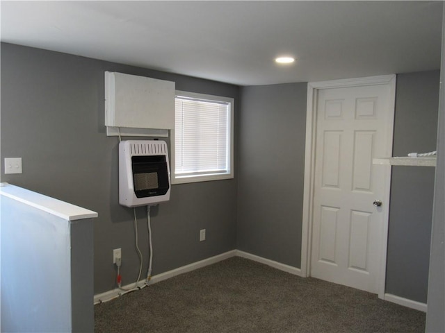 interior space with baseboards, dark carpet, and heating unit