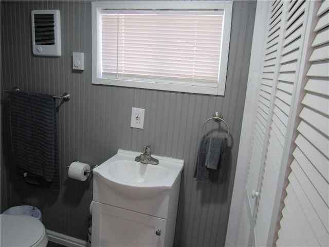 bathroom with a closet, vanity, and toilet