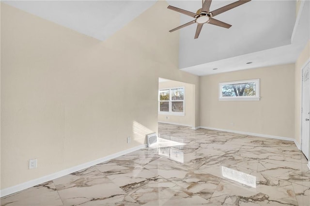 unfurnished room featuring marble finish floor, baseboards, a high ceiling, and visible vents