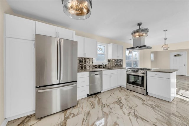 kitchen with stainless steel appliances, dark countertops, decorative light fixtures, and white cabinets