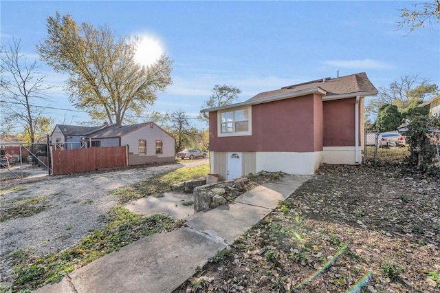 view of side of property featuring fence and stucco siding