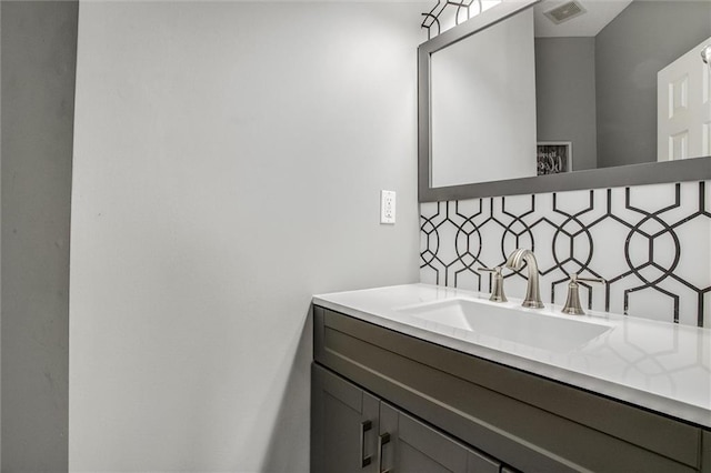 bathroom with visible vents, backsplash, and vanity