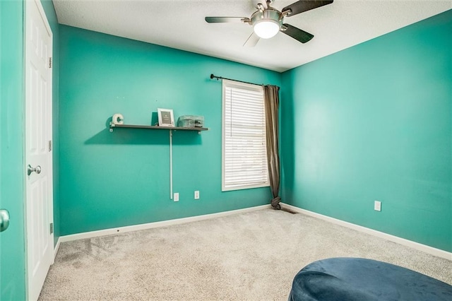 interior space with ceiling fan, baseboards, and carpet