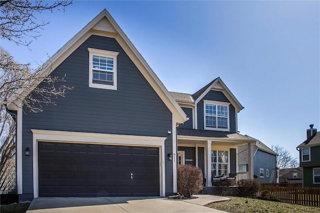 view of front of property with an attached garage, driveway, and fence