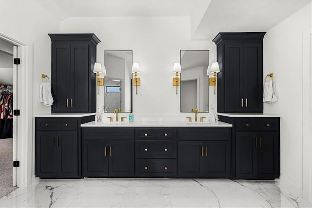 bathroom with a walk in closet, double vanity, marble finish floor, and a sink