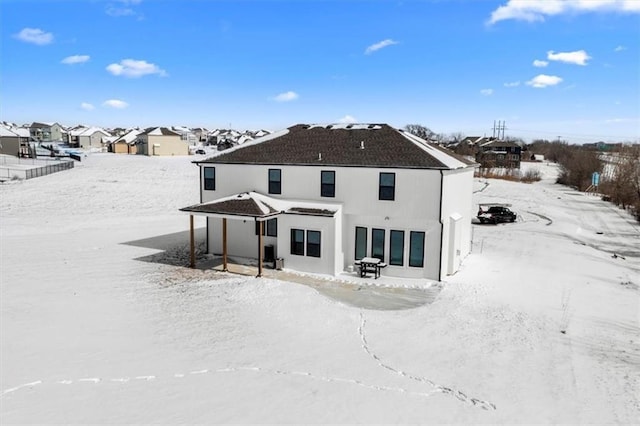 view of snow covered back of property