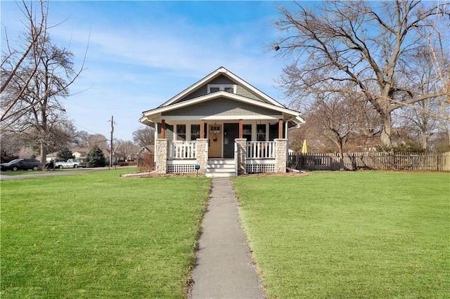 view of front of property featuring a porch, fence, and a front yard