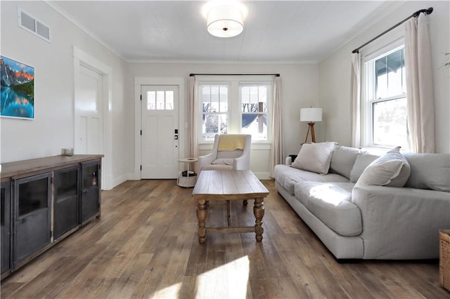 living room with visible vents, a healthy amount of sunlight, crown molding, and wood finished floors