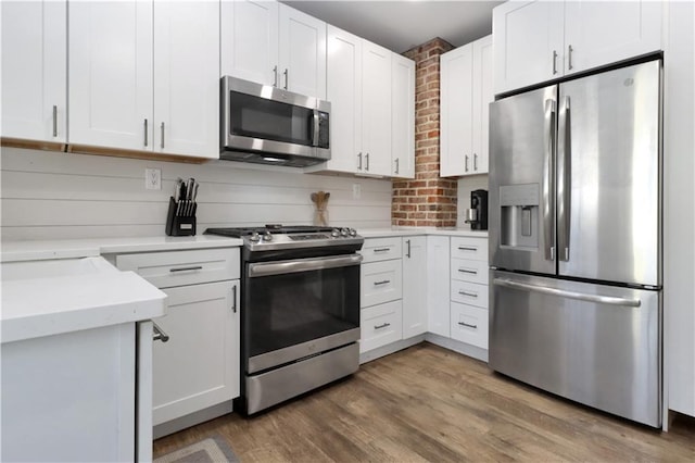 kitchen featuring appliances with stainless steel finishes, white cabinetry, and light wood-style floors