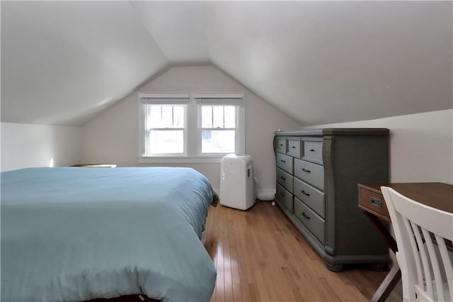 bedroom with light wood-style flooring and lofted ceiling