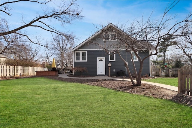 back of property featuring a yard, central AC unit, and fence