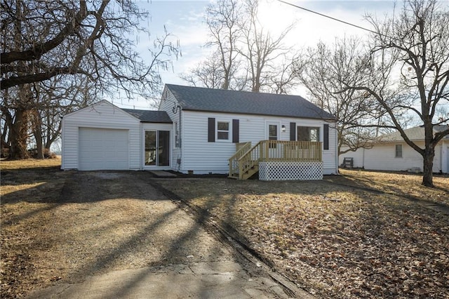 view of front of home featuring a garage, driveway, and a shingled roof