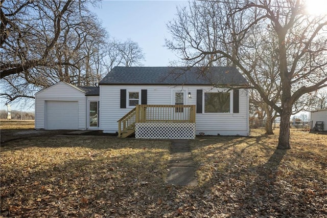 view of front facade with roof with shingles, an attached garage, and an outdoor structure