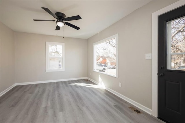 interior space with visible vents, ceiling fan, baseboards, and wood finished floors