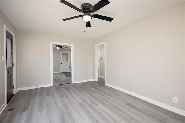 unfurnished bedroom featuring a ceiling fan, visible vents, baseboards, and wood finished floors