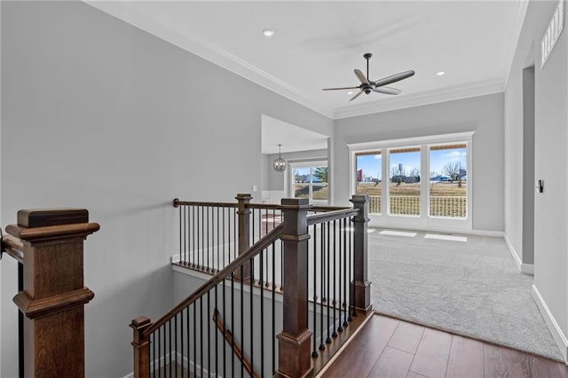 staircase with ornamental molding, wood finished floors, a ceiling fan, and baseboards