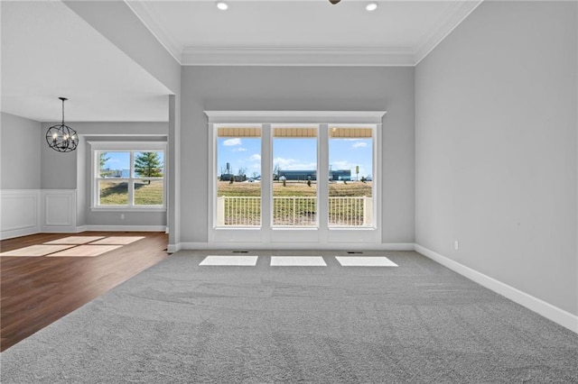 unfurnished living room featuring baseboards, ornamental molding, recessed lighting, and a notable chandelier