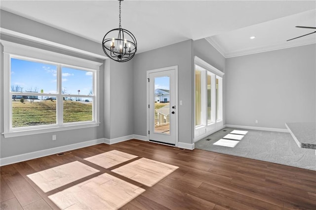 interior space with visible vents, baseboards, wood finished floors, an inviting chandelier, and crown molding