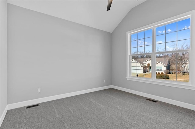 carpeted empty room featuring lofted ceiling, baseboards, and visible vents