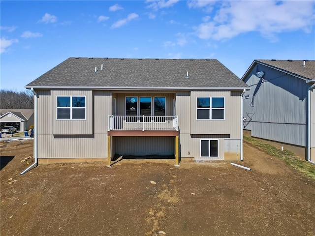 back of property with a shingled roof