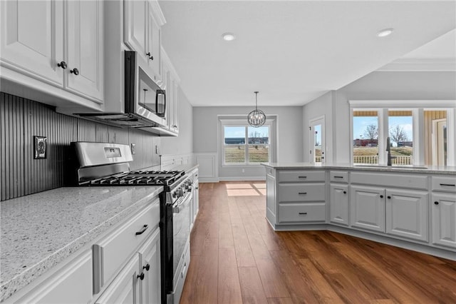 2407 Merlot Pl, Excelsior Springs, MO 64024 - kitchen with stainless steel appliances, dark wood finished floors, white cabinets, light stone counters, and a chandelier