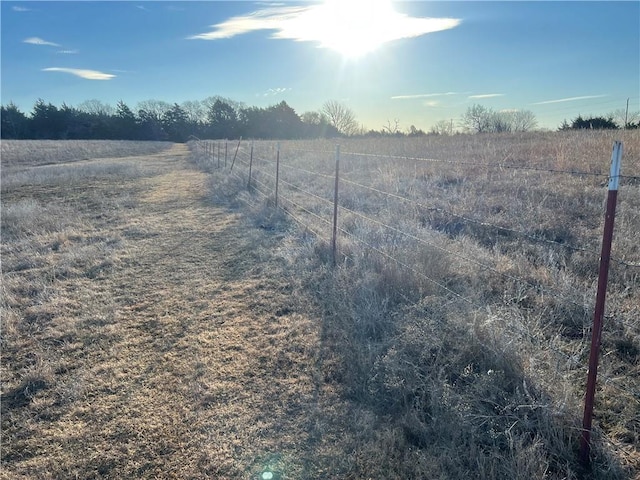 view of yard with a rural view and fence