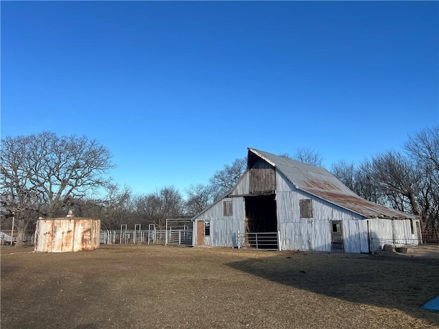 view of barn featuring a yard and fence