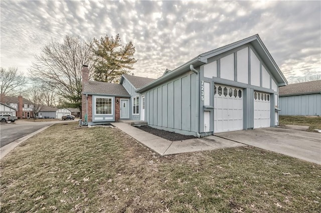 view of front of house with concrete driveway, a chimney, an attached garage, board and batten siding, and a front yard