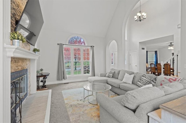 living area with carpet floors, plenty of natural light, high vaulted ceiling, and a tiled fireplace