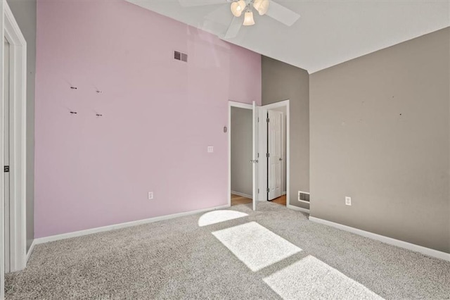 unfurnished bedroom featuring lofted ceiling, light carpet, visible vents, and baseboards