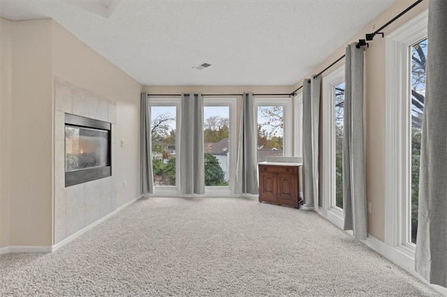 spare room with carpet flooring, visible vents, and a healthy amount of sunlight