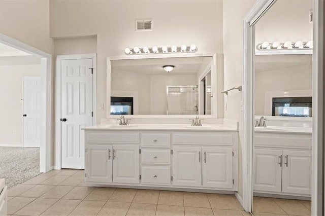 bathroom featuring double vanity, visible vents, a sink, and tile patterned floors