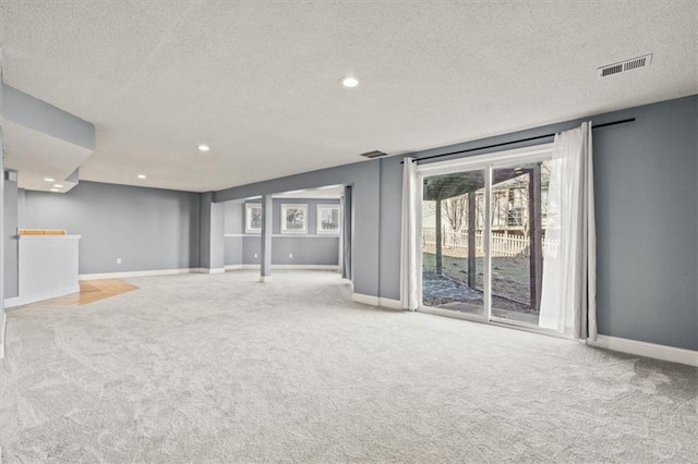 unfurnished living room featuring carpet floors, recessed lighting, visible vents, and baseboards