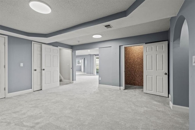 unfurnished bedroom featuring carpet floors, visible vents, and a textured ceiling