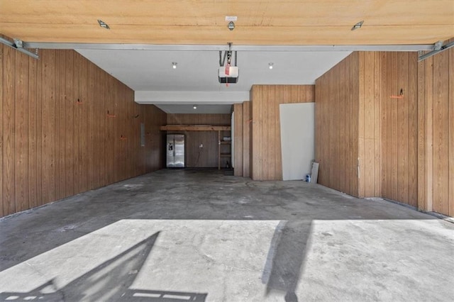 garage featuring wood walls and a garage door opener