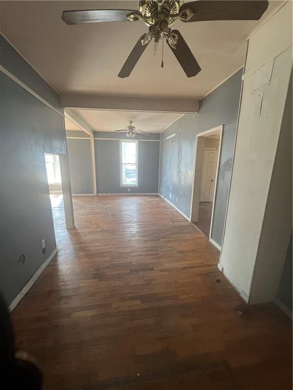 corridor featuring dark wood-type flooring and baseboards