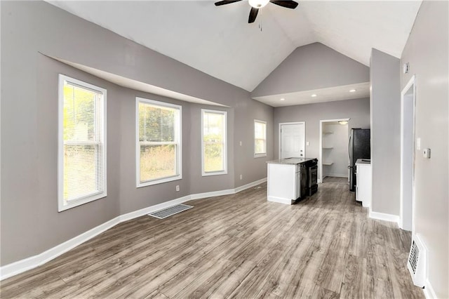 unfurnished living room with a wealth of natural light, visible vents, and light wood-style floors