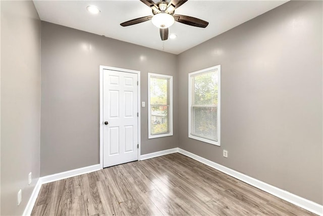spare room with ceiling fan, recessed lighting, wood finished floors, and baseboards