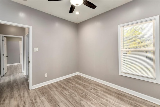 unfurnished room featuring light wood-style flooring, baseboards, and a ceiling fan