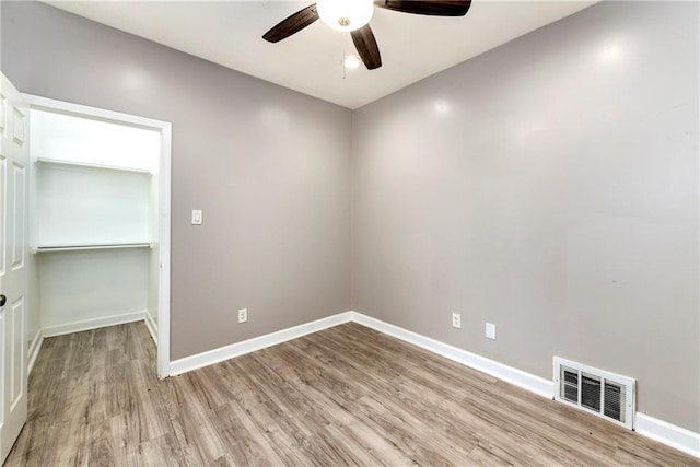 unfurnished room featuring light wood-type flooring, ceiling fan, baseboards, and visible vents
