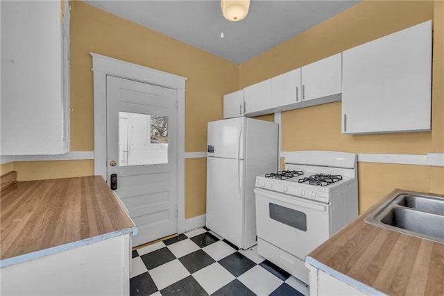 kitchen with light floors, light countertops, white cabinets, a sink, and white appliances