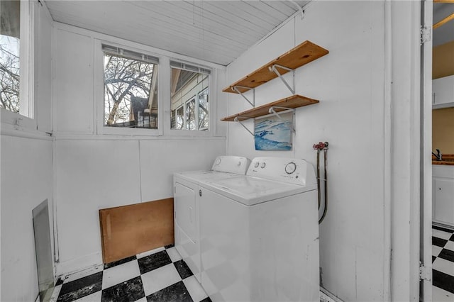 laundry area with laundry area, a sink, washing machine and clothes dryer, and tile patterned floors