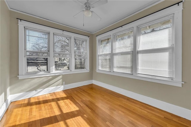 unfurnished sunroom featuring a ceiling fan