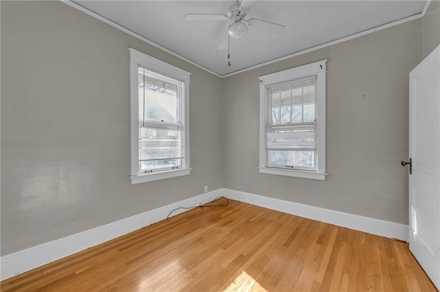 unfurnished room with a ceiling fan, baseboards, crown molding, and wood finished floors